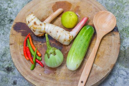 vegetables with wooden spoon on wooden shopping blockの写真素材