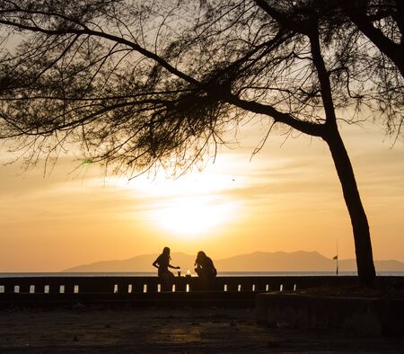 silhoulette of two wamen at the beachの写真素材
