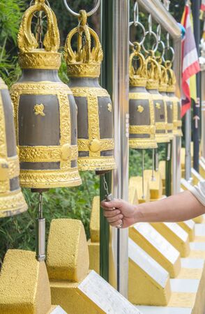hand of man rining bell in the Buddhist temple of Thailandの写真素材