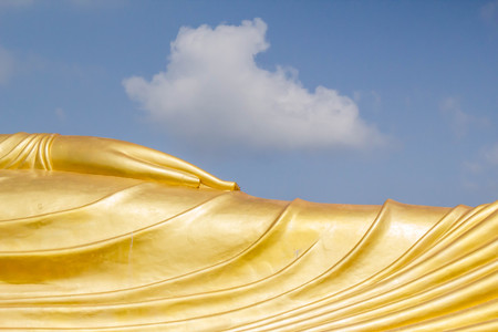 hand of huge golden sleeping Buddha with blue sky at Songkhla Thailand.の写真素材