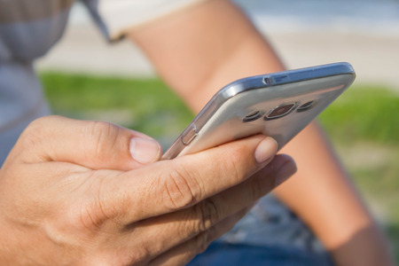 Close up of a man using mobile smart phone