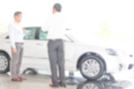 blur photo of car showroom with salesman and customersの写真素材