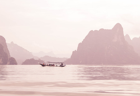 tourist in boat at Ratchaprapa Dam (Chaew Lan Dam) Surat Thani, Thailand photo in pink filterの写真素材