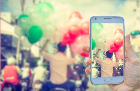 hand take photo man on motorcycle with color ballons in his handsの写真素材