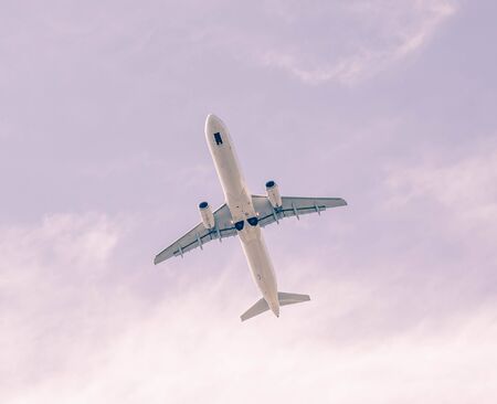 white airplane in blue sky in pink filterの写真素材