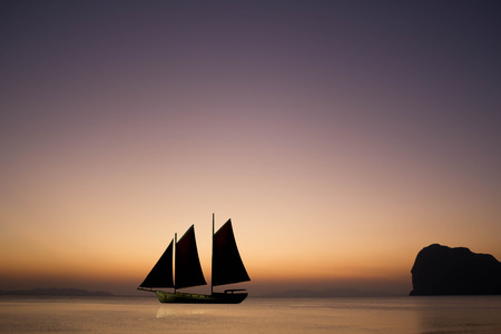 sailing boat in the sea with sunset skyの写真素材