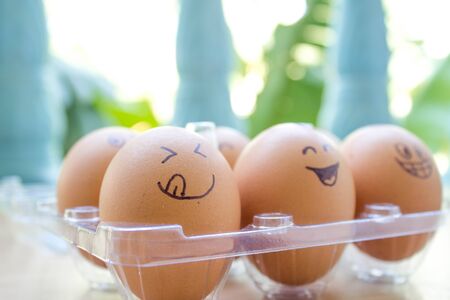 funny eggs with painted face in the box