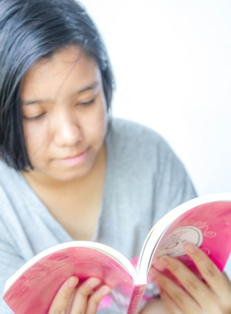 happy Asian young girl reading bookの写真素材