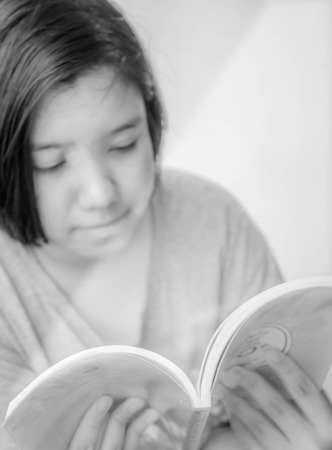 happy Asian young girl reading book with white light from left side