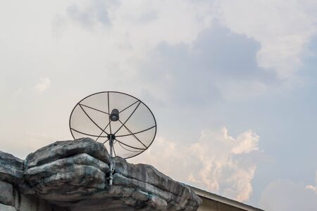 satellite dish on the rock roof with blue sky and white cloud backgroundの写真素材