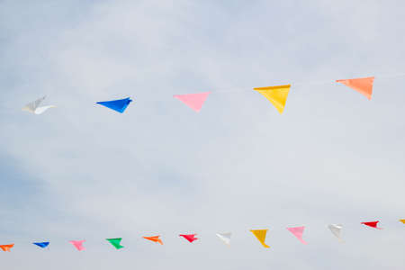 colorful festive bunting flags against a blue sky backgroundの写真素材