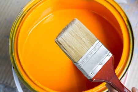 paint brush on abstract orange paint color in bucketの写真素材