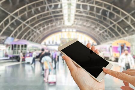 hand using smart phone with blur background photo of train at the stationの写真素材