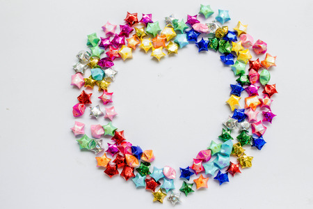 colorful folded paper star or origami lucky star in heart shaped to use as frame