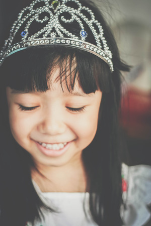 Happy Asian girl smiling when put crown like princess