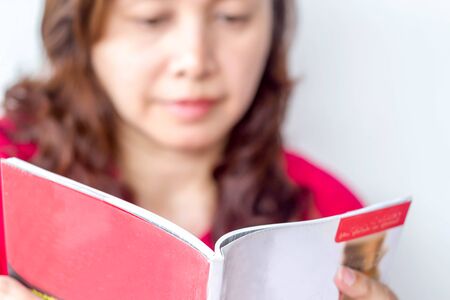blurred  woman reading book selevtive focus on bookの写真素材