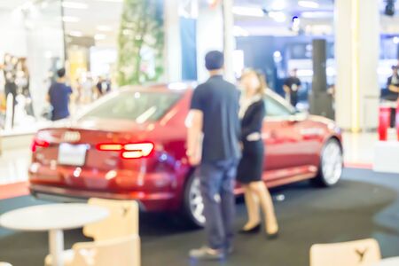 blurred car showroom with customer and saleswomanの写真素材