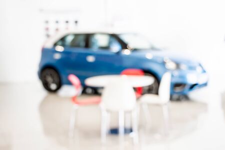 blurred car showroom with blue car and set of table and chairs : for background useの写真素材