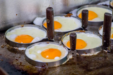 eggs flying in circle mold on hot panの写真素材