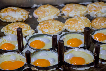 eggs flying in circle mold on hot panの写真素材