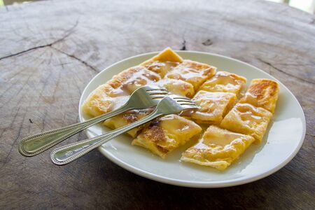 Roti with eggs : traditional Southern Muslim food in white plate on wood tableの写真素材