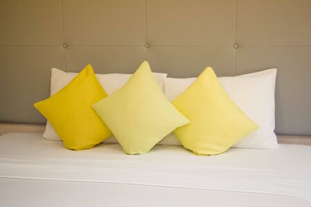 yellow pillows on white bed in modern roomの写真素材