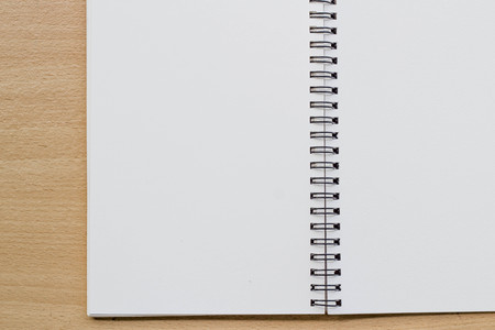 opened spiral blank notebook on wood table
