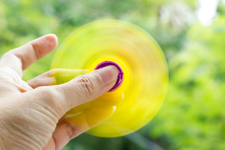 Fidget spinner (Hand spinner) fast spinning  in hand on nature backgroundの写真素材
