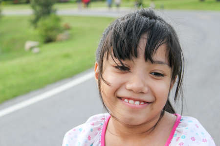 happy Asian young girl with pink bow smilingの写真素材