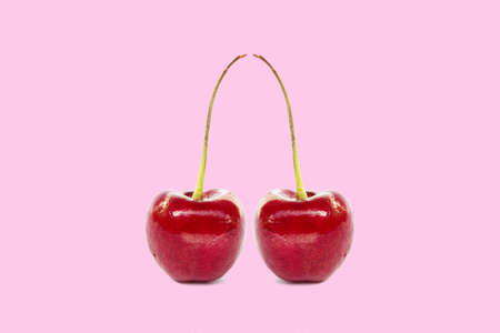 two red cherry isolated on pink background