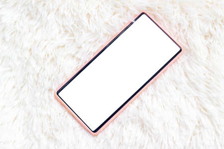 smart phone in pink case with blank screen on white fur backgroundの写真素材