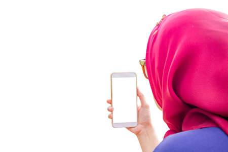 Muslim woman taking photo on mobile phone isolated on white backgroundの写真素材