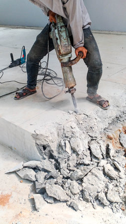 Construction Thai local worker using heavy-duty tool and breaking reinforced concrete. Demolishing...