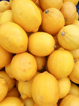 Lemon stack in the supermarket basket, a pile of fresh, ripe lemons top view. Rich vitamin c, natural and fresh lemon stack.の写真素材