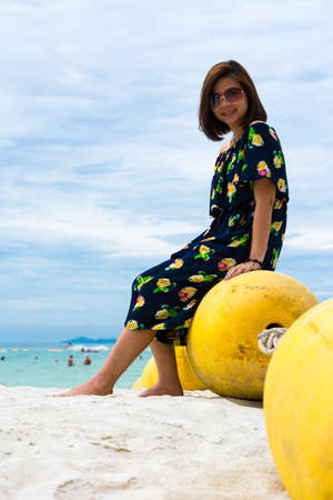 Girl sitting on buoy near seaの写真素材