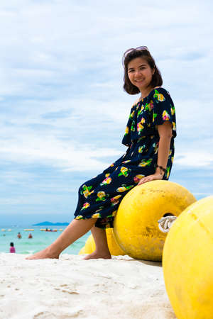Girl sitting on buoy near seaの写真素材
