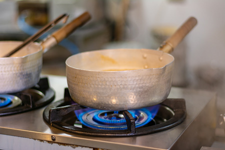 Cook with a large iron pan, boilingの写真素材