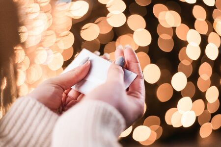 Female hands hold hand warmers on night lights background.の写真素材