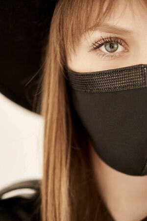 Young woman wearing black mask. Beautiful fashion protective mask with rhinestones for stylists....