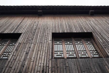 The interior of the old building. A Chinese-style building. Chinese wooden wall with windows. Background of architecture details.の写真素材
