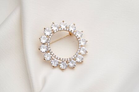Golden brooch with small diamonds,  isolated on white background. Women Accessoriesの写真素材