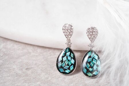 Modern earrings with small crystals on gentle background. Women accessories.の写真素材