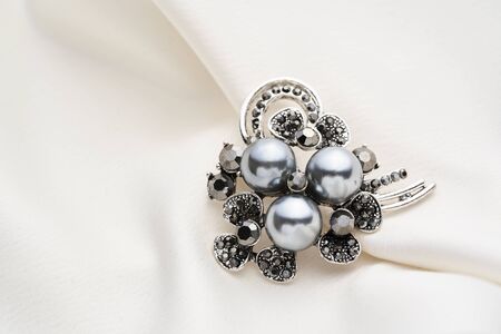 Silver brooch  with small diamonds and black pearls,  isolated on white background. Women Accessoriesの写真素材