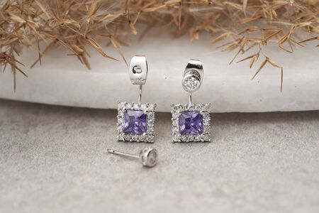 Silver earrings isolated, with white crystals and purple diamond in the middle. Beautiful earrings...