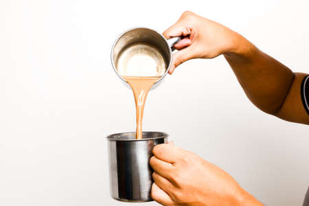 A picture of men preparing teh tarik. Sweet milk tea been pull for mix well and create foam that is...