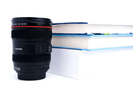 A picture of lens shape mug used by student while study for his exam with and books insight.の写真素材
