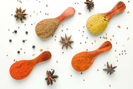 A high key flatlay closeup picture of herbs spoon with Turkish mix spices, coriander, paprika, curry, star anise, black pepper and aromatic seeds before marinating food.の写真素材