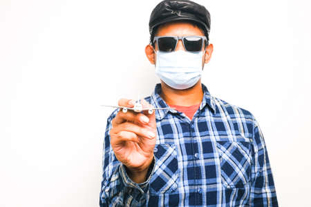 Selective focus picture of men wearing face mask holding miniature aircraft insight.