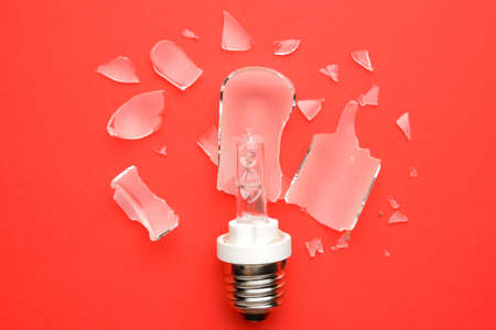 A picture of broken E27 type modelling light bulb on red background.の写真素材