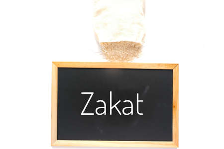 A picture of rice bag and blackboard written zakat. Zakat is a form of alms-giving treated in Islam as a religious obligation or tax.の写真素材